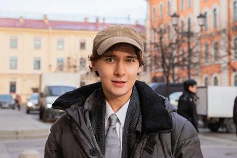 Man student looking at camera on the street during his break. Young guy in .. Stock Photos