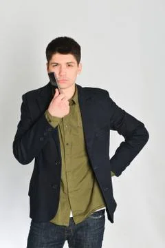 Man, student or freelancer in a jacket, emotionally posing with a phone Stock Photos