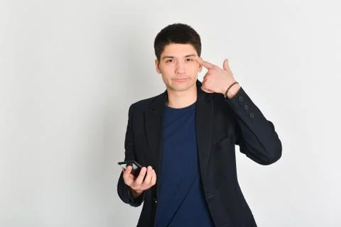 Man, student or freelancer in a jacket, emotionally posing with a phone Stock Photos