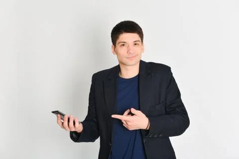 Man, student or freelancer in a jacket, emotionally posing with a phone Stock Photos