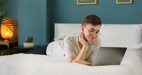 Man student using laptop enjoying watching video, streaming service Stock Footage 136547162