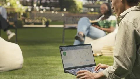 Man student working with solar panels data for sustainable energy on laptop Stock Photos