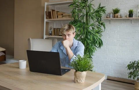 A man studies and takes notes with a laptop studying house plants, performs s Stock Photos