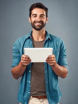 Man, studio and portrait with tablet and smile, career with software programming Stock Photos