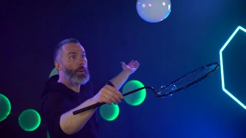 Man in the Studio blows soap bubbles Stock Footage 141708331