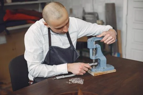 Man in a studio creates leather ware Stock Photos