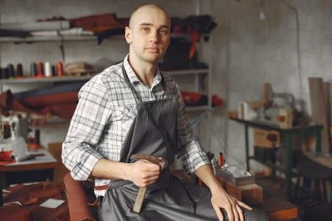 Man in a studio creates leather ware Stock Photos