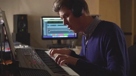 Man in the studio emotionally plays on electronic piano Stock Footage 72290929