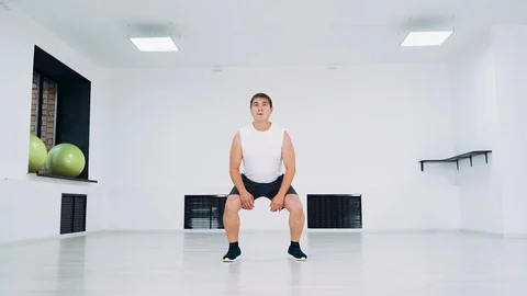 A man in the studio performs a burpee exercise. Stock Footage 114164760
