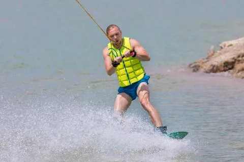 Man study wakeboarding on a blue lake Stock Photos
