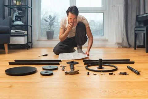 A man is studying the furniture assembly algorithm described in the instruc.. 스톡 사진