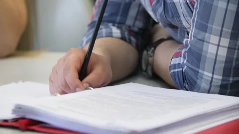 Man studying online writing notes on paper, hands close-up. Video stock 262546608
