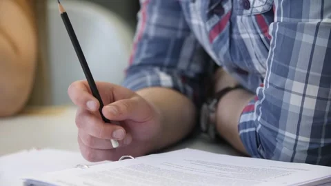Man studying online writing notes on paper, hands close-up. Stock Footage 262546615