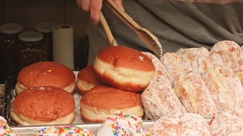 A man stuffs doughnuts into a plate Stock Footage 304305689