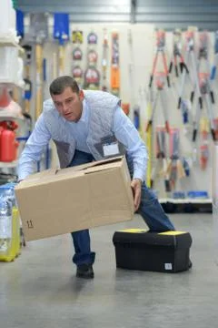 Man stumbling while carrying box Stock Photos