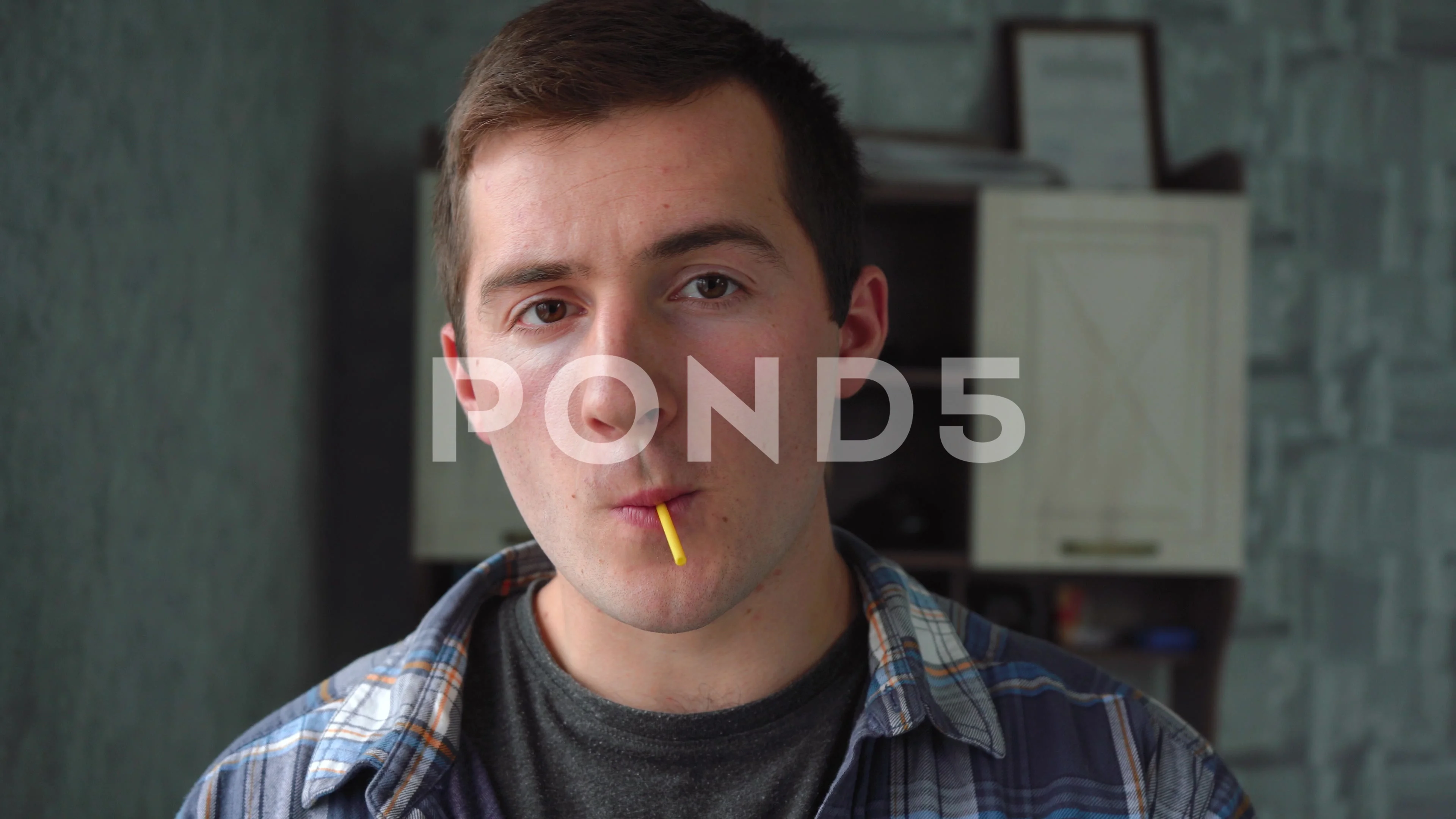 a man sucking an orange lollipop