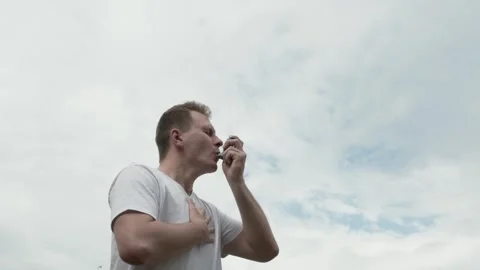 Man suffering from an asthma attack and using asthma inhaler Stock Footage 244195208