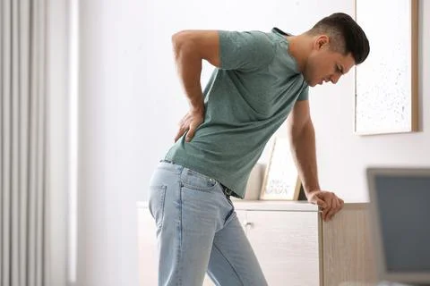 Man suffering from back pain at home. Bad posture problem Stock Photos