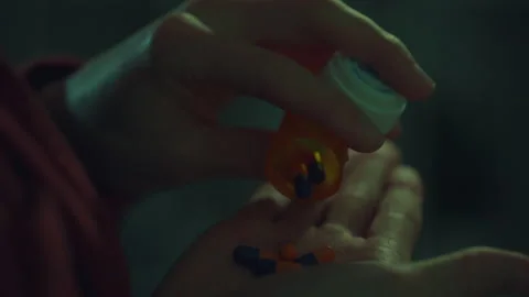 A man suffering from headache takes out a bottle of pills from an orange box Stock Footage 256938939