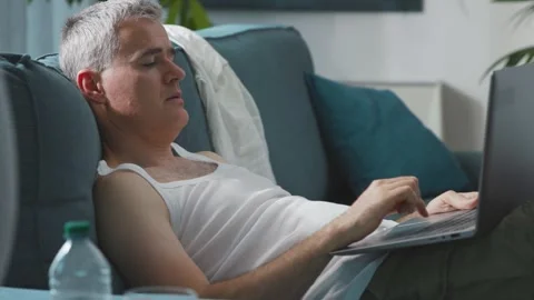 Man suffering from the heat and working with a laptop Stock Footage 297860972