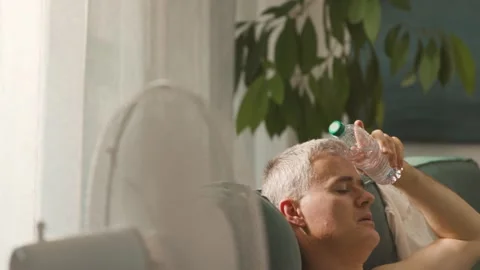 Man suffering from the heat and working with a laptop Stock Footage 297861003
