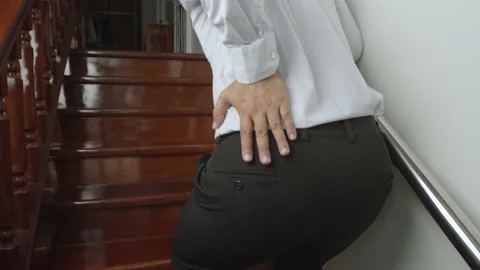 Man suffering from low back pain while walking up the stairs Stock Footage 236200340