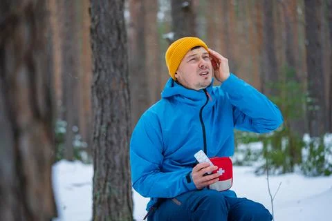 Man suffering from severe headache or migraine attack during winter hike Stock Photos