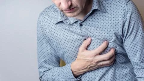 Man suffering from severe sharp heartache, chest pain. Heart disease concept Stock Photos