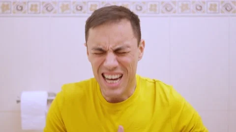 Man suffering from stomach ache while sitting on toilet Stock Footage 312310981