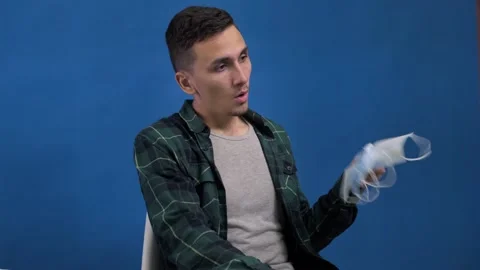 Man suffers from heat using stack of medical masks instead of a fan Stock Footage 162543891