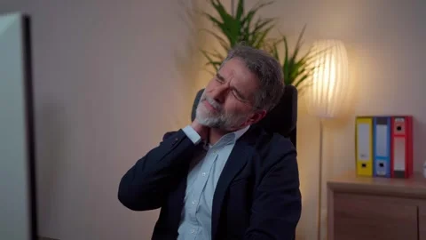 A man suffers from neck pain while working in the office Video stock 268328309