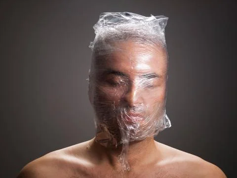Man suffocating with plastic around his head Stock Photos