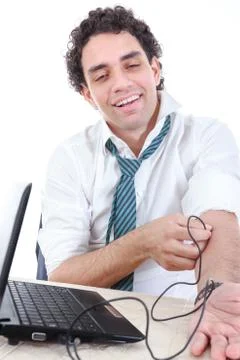 Man in suit addicted to internet put usb cable from laptop computer into his  Stock Photos
