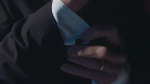 Man in suit adjusting cuff links Stock Footage 102773179