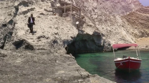 Man in suit with briefcase walking down stone steps while talking on his Vídeo Stock 77724805