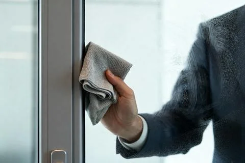 Man in suit cleaning a window with a microfiber cloth Stock Photos