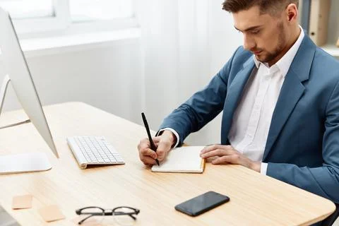 A man in a suit computer desktop work self-confidence paper folder executive Stock Photos