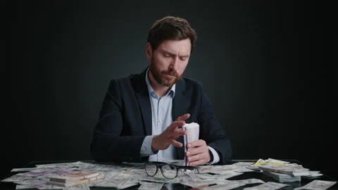 A man in a suit counting a stack of money before putting on glasses. Stock Footage 237562253