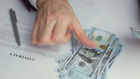 Man in suit counts 100 dollar bills before signing contract Stock Footage 168025710