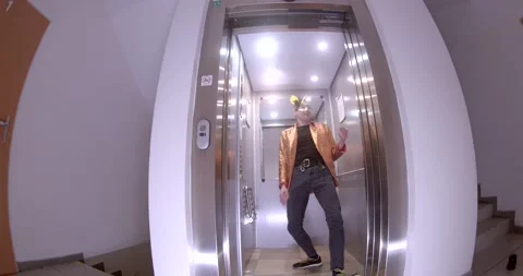A man in a suit dances energetically in an elevator, adding mystery Видео 311817911