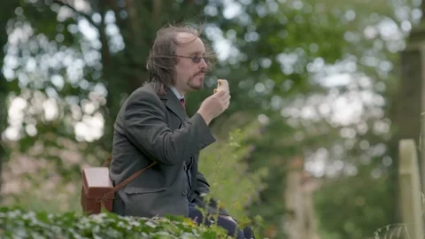 Man In Suit Eats Peanut Butter and Cheese Sandwich In Graveyard Видео 138671791