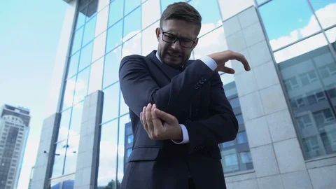 Man in suit feeling acute elbow pain outdoors, joint inflammation, arthritis Stock Footage 119286887