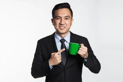 Man in suit holding a mug while pointing at it Stock Photos