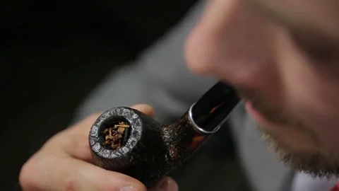 Man in a suit ignites a smoking pipe. Close-up Stock Footage 72139855