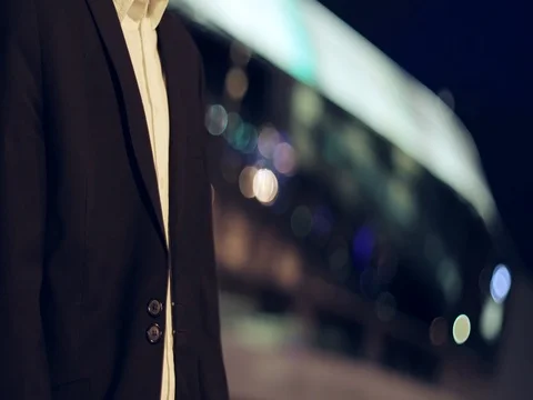 A man in a suit jacket crosses arms on chest standing in the night city. Stock Footage 77179548