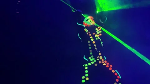 Man in suit with light-reflecting elements dances at club Stock Footage 152077211