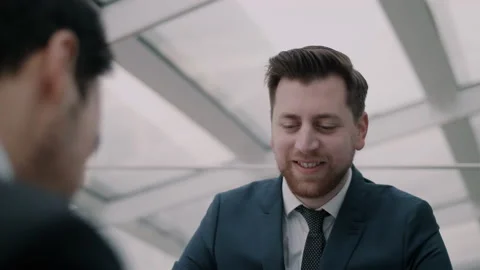 Man in suit looking happy while sitting behind desk Stock Footage 131028457