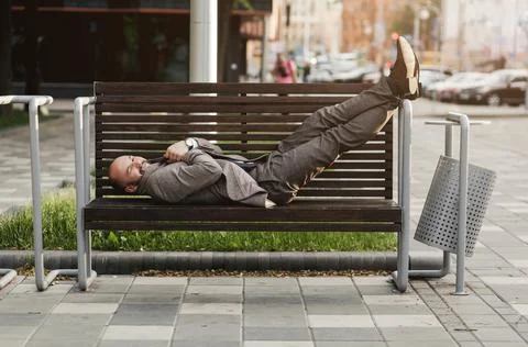 Man in a suit is lying on a bench Stock Photos