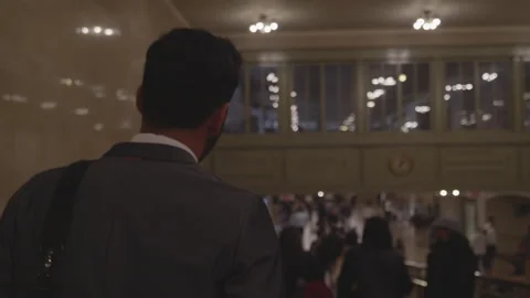 Man in suit navigates crowded building during busy evening hours Stock Footage 312685268