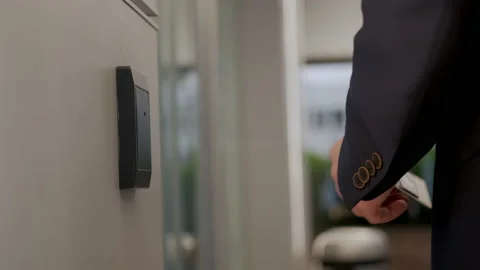 Man in suit opens the door to office building, using a NFC key card, Video stock 166975150